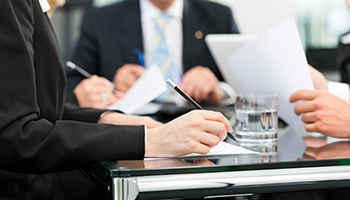 A group of diverse business professionals seated around a conference table